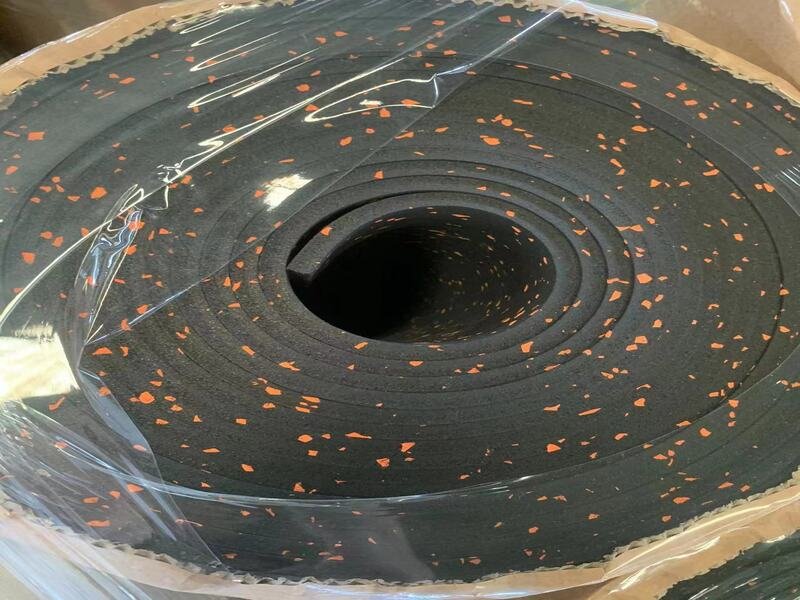 Чистый пол в тренажерном зале, куда свет проникает через большие окна, демонстрирует ухоженную поверхность